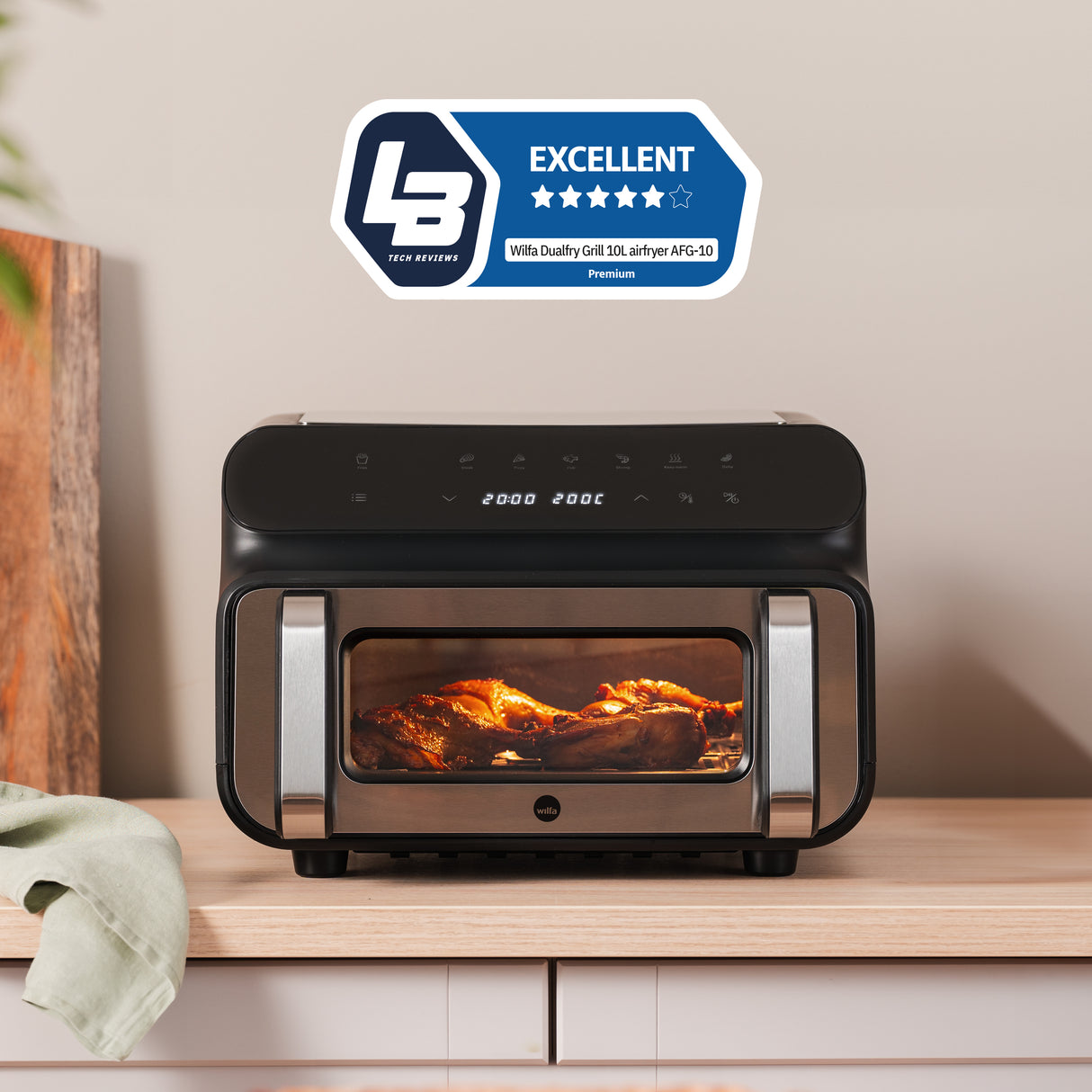 A modern black and stainless steel DUALFRY GRILL 10L air fryer with dual heating elements and a digital control panel on top. Inside the glass door, food is visible being cooked. The display shows the temperature as 200°C and the time remaining as 18 minutes. A truly powerful air fryer.