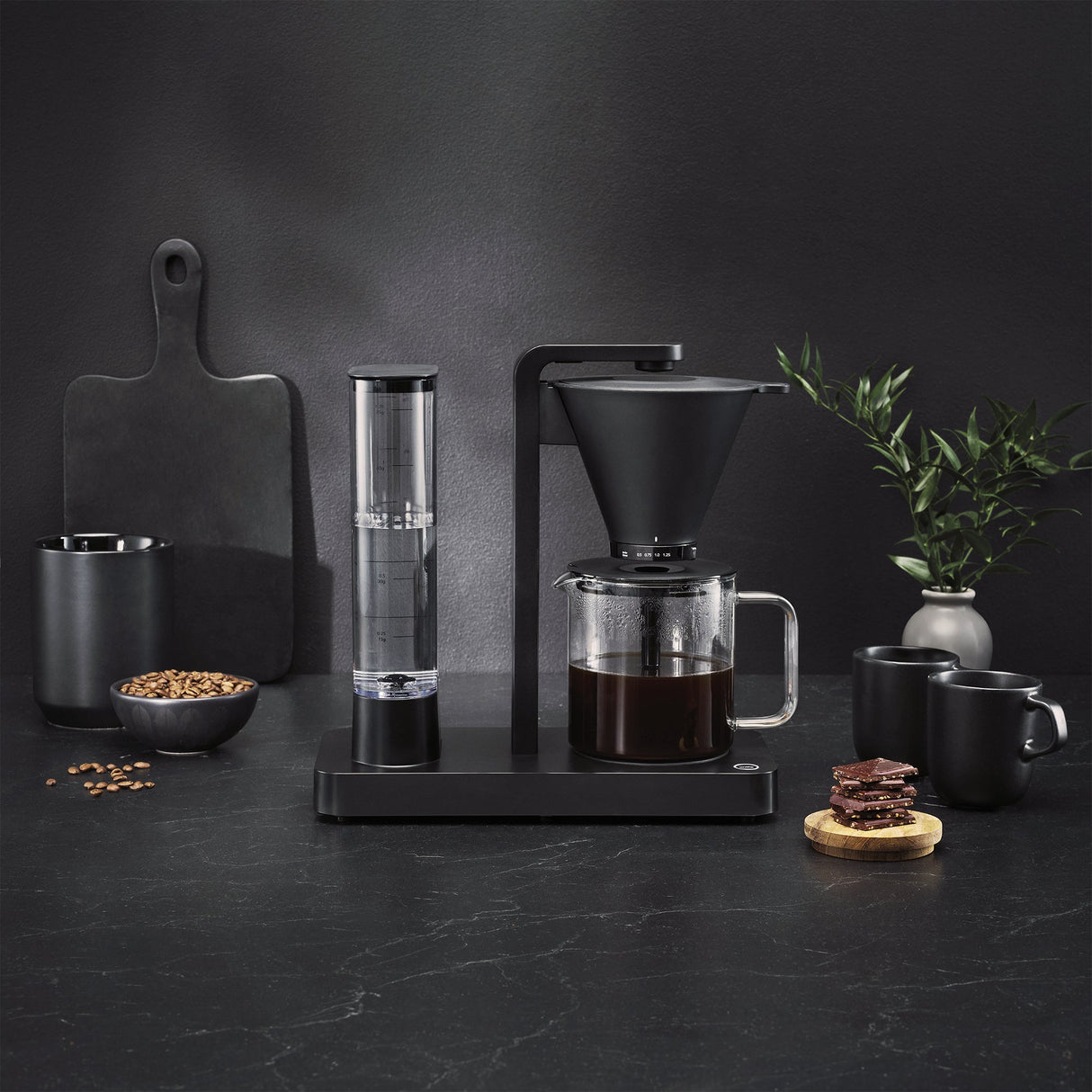 Une cafetière PERFORMANCE BLACK dotée d'un réservoir d'eau transparent et d'une carafe en verre remplie de café. Équipée d'une technologie unique garantissant une température idéale, elle arbore deux insignes de distinction : l'un, orné d'une couronne de laurier, portant la mention « Best i Test Tek.no », et l'autre, sur lequel on peut lire « Testvinner », accompagné d'étoiles et d'un ruban.