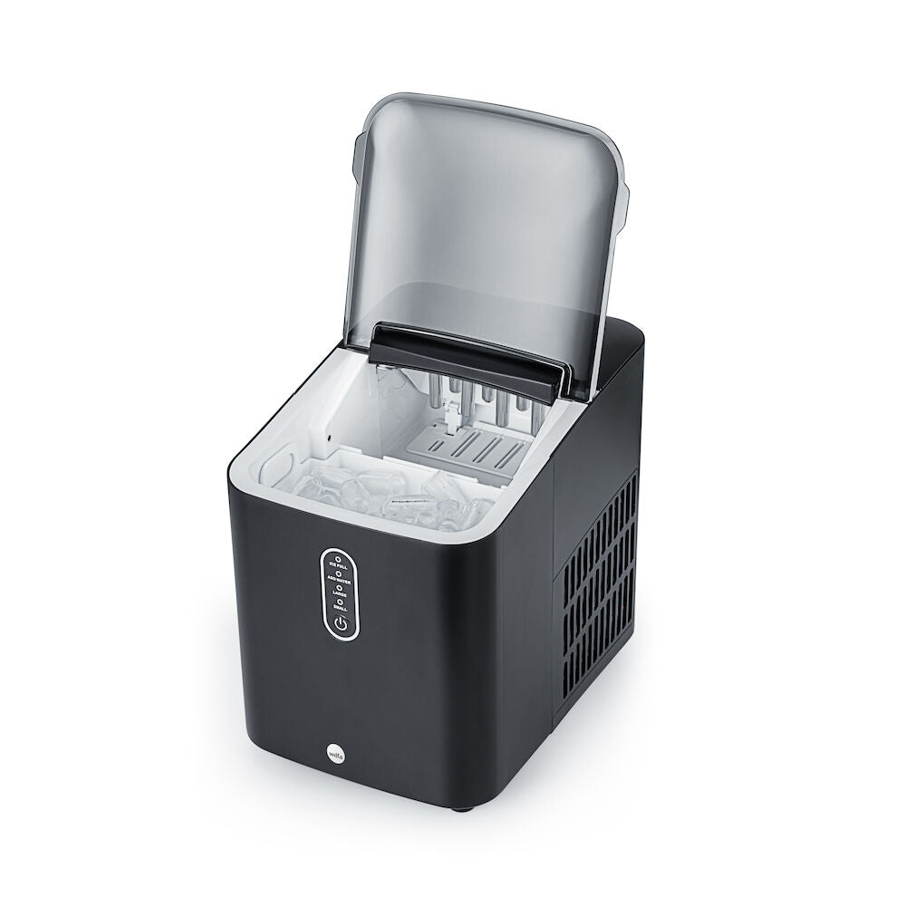 Una elegante y sofisticada nevera GLACIER de color negro mate descansa junto a una pequeña cubitera llena de cubitos de hielo. Su diseño moderno cuenta con un panel de control en la parte frontal y rejillas de ventilación en los laterales. Gracias a su gran capacidad y a su tapa superior cerrada, es perfecta para cualquier cocina contemporánea.