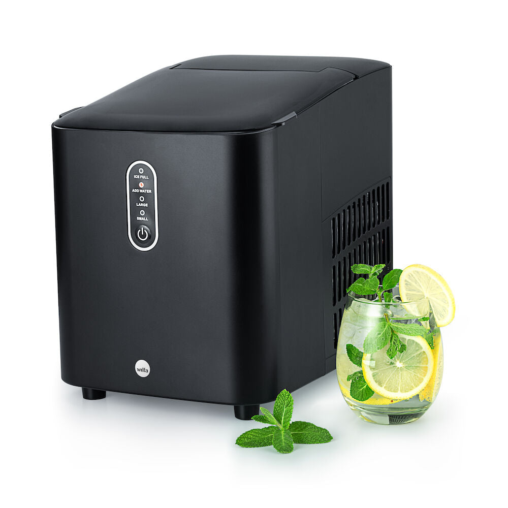 Una elegante y sofisticada nevera GLACIER de color negro mate descansa junto a una pequeña cubitera llena de cubitos de hielo. Su diseño moderno cuenta con un panel de control en la parte frontal y rejillas de ventilación en los laterales. Gracias a su gran capacidad y a su tapa superior cerrada, es perfecta para cualquier cocina contemporánea.