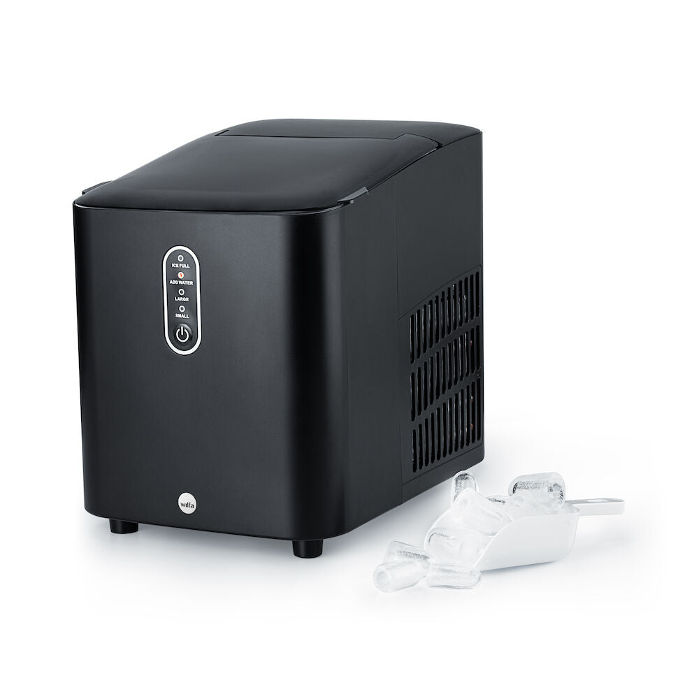 Una elegante y sofisticada nevera GLACIER de color negro mate descansa junto a una pequeña cubitera llena de cubitos de hielo. Su diseño moderno cuenta con un panel de control en la parte frontal y rejillas de ventilación en los laterales. Gracias a su gran capacidad y a su tapa superior cerrada, es perfecta para cualquier cocina contemporánea.