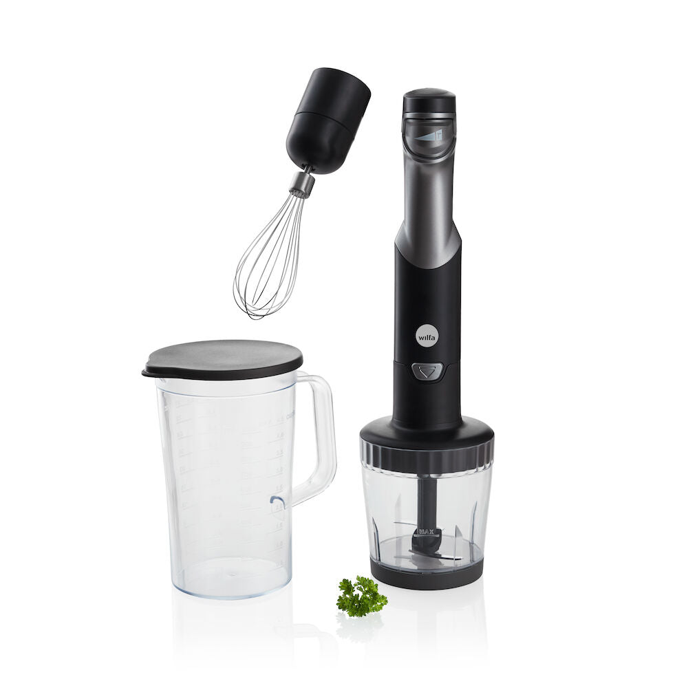 Un juego ESSENTIAL POWER en negro y plateado, con un potente motor y control de velocidad continuo, compuesto por tres elementos: el mango de la batidora, una jarra medidora transparente llena de cebollas rojas picadas y un accesorio transparente para el robot de cocina que contiene verduras picadas, entre ellas cebollas rojas y pimientos verdes.