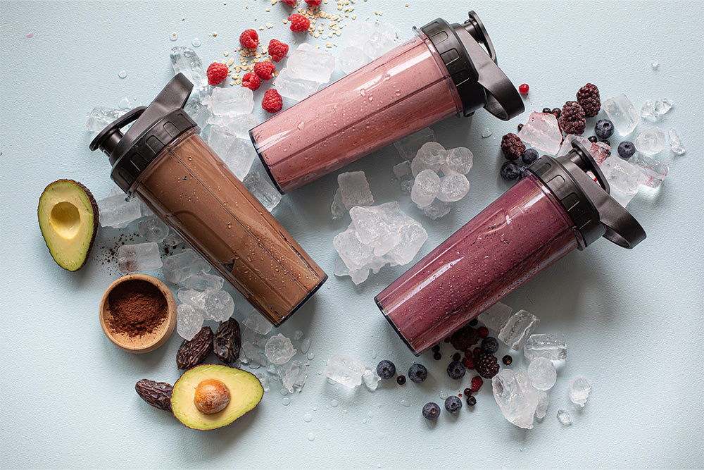 Three smoothies in 2GO bottles with fresh berries, chocolate and ice