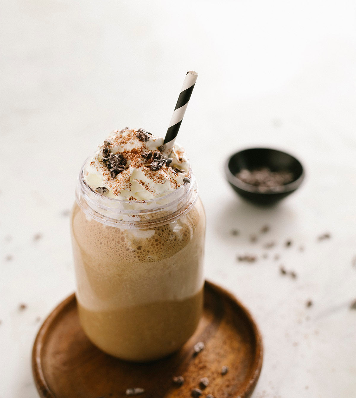Glass jar of hot chocolate topped with whipped cream and grated chocolate