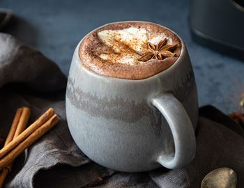 Mug of chai hot chocolate with star anise and cinnamon sticks