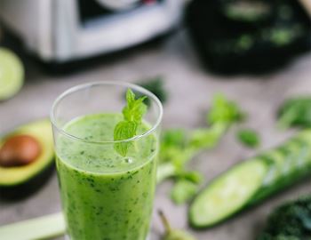 Green super smoothie in a glass with mint, cucumber and avocado