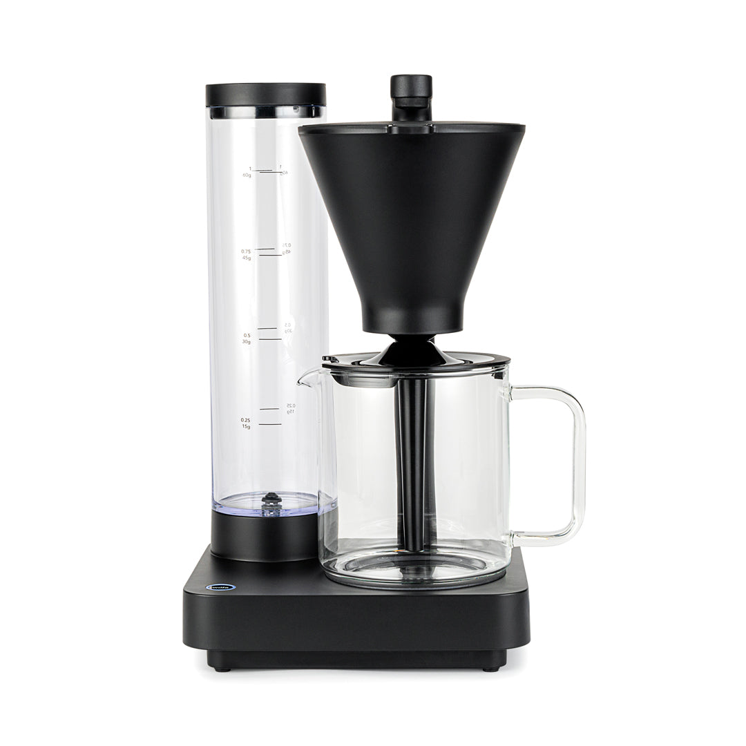 A clear glass pitcher with a black plastic lid and handle. The PERFORMANCE COMPACT COFFEE JUG W/LID, ideal for holding up to 10 cups, features a spout for pouring and a central black infuser tube extending from the lid into the body of the pitcher. The design is modern and minimalist.