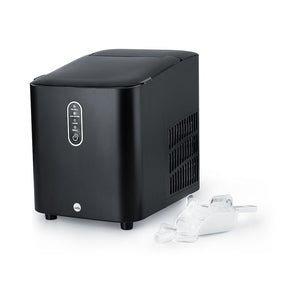 Una elegante y sofisticada nevera GLACIER de color negro mate descansa junto a una pequeña cubitera llena de cubitos de hielo. Su diseño moderno cuenta con un panel de control en la parte frontal y rejillas de ventilación en los laterales. Gracias a su gran capacidad y a su tapa superior cerrada, es perfecta para cualquier cocina contemporánea.